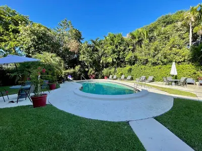 a swimming pool in a yard with a table and chairs at 2Bdrm 1Bath Newly Renovated Condo - Walk to the Beach! in Fort Lauderdale