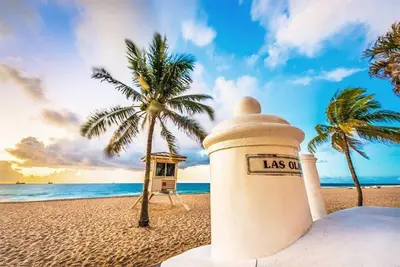 a lighthouse on a beach with palm trees and the ocean at 2Bdrm 1Bath Newly Renovated Condo - Walk to the Beach! in Fort Lauderdale
