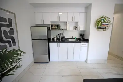 a kitchen with white cabinets and a stainless steel refrigerator at Family Pet Friendly Apartment 3 Minute Walk to Miami Beach in Miami Beach