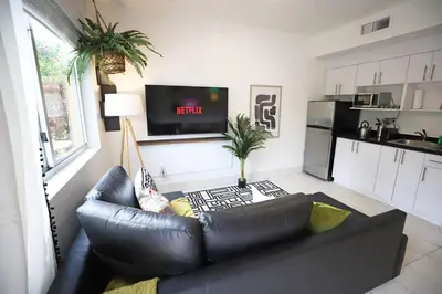 a living room with a leather couch and a tv at Family Pet Friendly Apartment 3 Minute Walk to Miami Beach in Miami Beach