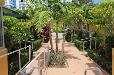 a walkway with palm trees next to a building at Family Friendly Condo Steps to Miami Beach with Free Parking in Miami Beach