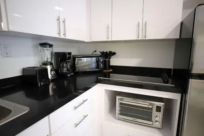 a kitchen with white cabinets and a microwave at 3 Bedroom 3 Bathroom Miami Beach Apartment in Miami Beach