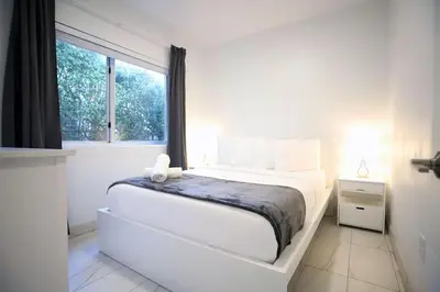 a white bedroom with a white bed and a window at 3 Bedroom 3 Bathroom Miami Beach Apartment in Miami Beach