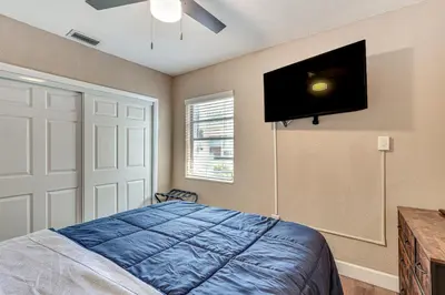 a bedroom with a bed and a tv on the wall at 11 Mi to South Beach Home with Screened Porch! in Miami