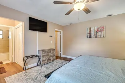 a bedroom with a bed and a flat screen tv at 11 Mi to South Beach Home with Screened Porch! in Miami