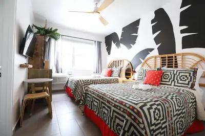a hotel room with two beds and a tv at Ocean Drive South Beach Miami in Miami Beach