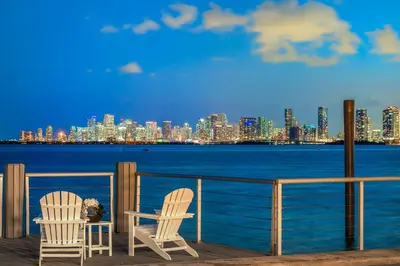 two chairs on a pier with a view of the city at Best Bayfront View Villa with Heated Pool in North Bay Village