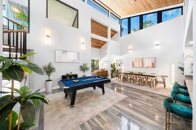 a living room with a pool table in the middle at Best Bayfront View Villa with Heated Pool in North Bay Village