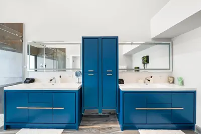 a bathroom with blue cabinets and two sinks at Best Bayfront View Villa with Heated Pool in North Bay Village