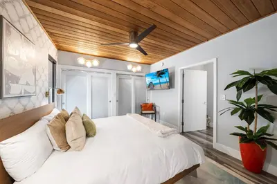 a bedroom with a white bed with a ceiling fan at Best Bayfront View Villa with Heated Pool in North Bay Village