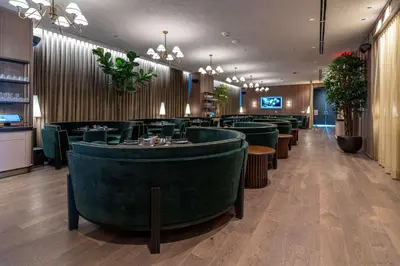 a restaurant with green chairs and a bar at Bayside Breeze - Downtown Luxury Tower in Miami