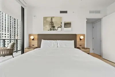 a bedroom with a large white bed and a large window at Bayside Breeze - Downtown Luxury Tower in Miami