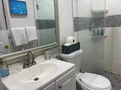 a bathroom with a sink and a toilet and a mirror at Private and Comfortable Suite near Airport Miami in Miami