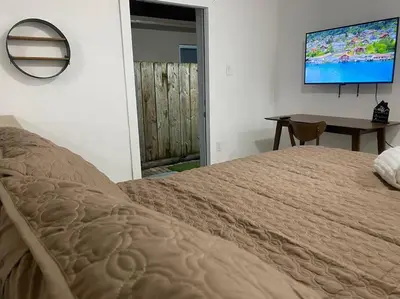a bedroom with a bed and a table and a television at Private and Comfortable Suite near Airport Miami in Miami