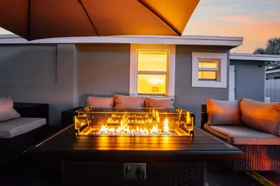 a living room with a fire pit on a patio at BOHO Elegance in the FLL city! in Fort Lauderdale