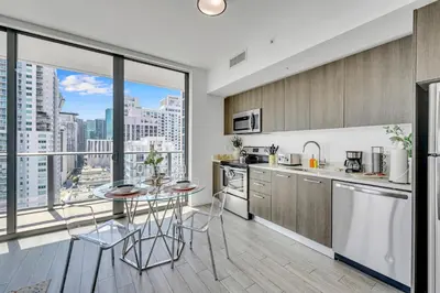 a kitchen with a table and a view of a city at Mesmerizing Water Views Corner Condo in Miami