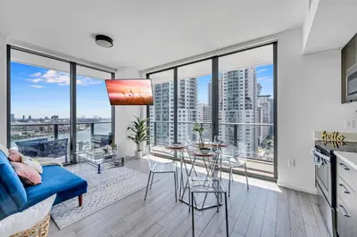 a living room with large windows and a table at Mesmerizing Water Views Corner Condo in Miami
