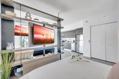 a living room with a large television on a wall at Mesmerizing Water Views Corner Condo in Miami