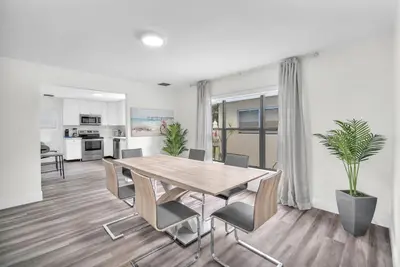 a kitchen and dining room with a table and chairs at Contemporary 4 Bedroom Oasis - Private Large Patio in North Miami