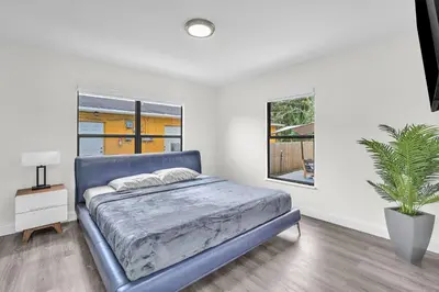 a bedroom with a blue bed and a potted plant at Contemporary 4 Bedroom Oasis - Private Large Patio in North Miami