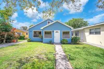 a blue house with a yard at Contemporary 4 Bedroom Oasis - Private Large Patio in North Miami