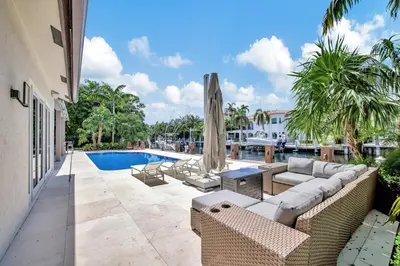 an outdoor patio with couches and a swimming pool at Elegant Waterfront Estate 6BR- 6.5BA in Fort Lauderdale
