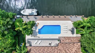 an overhead view of a house with a swimming pool and a boat at Elegant Waterfront Estate 6BR- 6.5BA in Fort Lauderdale