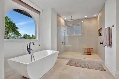 a bathroom with a large white tub and a window at Elegant Waterfront Estate 6BR- 6.5BA in Fort Lauderdale