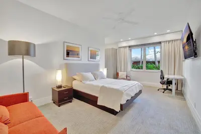 a bedroom with a bed and a couch and a desk at Elegant Waterfront Estate 6BR- 6.5BA in Fort Lauderdale