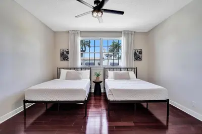 two beds in a room with a window at Spacious Luxury Villa in Hollywood 6BR 5-Bath 5-Min Walk to Beach & Attractions in Hollywood