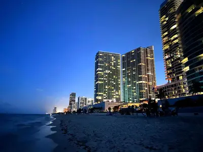 a beach with skyscrapers in the city at night at Amazing beachfront condo at Tides on Hollywood Beach Luxury Resort in Hollywood