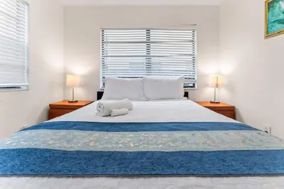 a bedroom with a large bed with two lamps at Spacious 5BR Home with Pool, Near Downtown & Beach in Hollywood