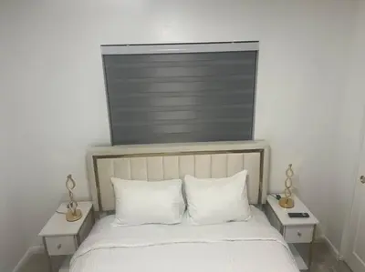 a bed with two white pillows and two tables at Hollywood Golden House Modern & luxurious Studio in Hollywood