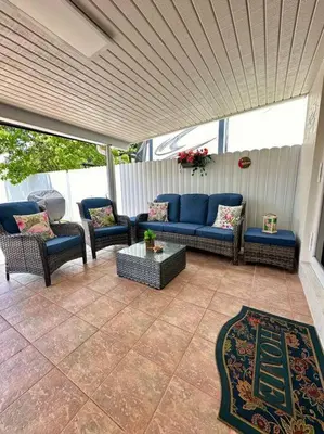a patio with a couch and chairs and a rug at Flamingo Paradise in Hialeah
