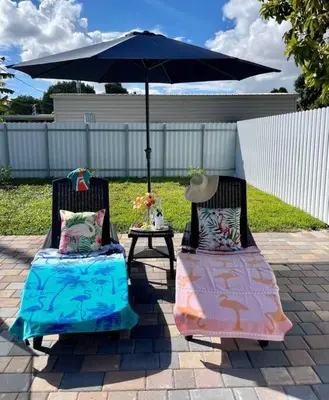 two chairs sitting under an umbrella on a patio at Flamingo Paradise in Hialeah