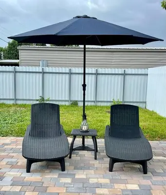 two chairs and a table with an umbrella at Flamingo Paradise in Hialeah