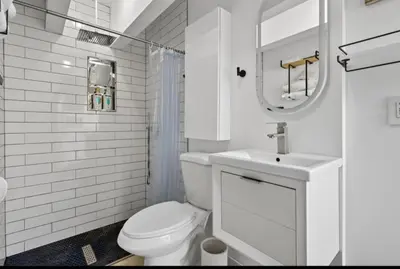 a white bathroom with a toilet and a sink at Fort Lauderdale airport and Dania Pointe shopping 5 min away in Fort Lauderdale