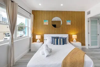 a bedroom with a large bed with a yellow wall at Ocean Views! Steps from Dining, Shopping, Las Olas in Fort Lauderdale