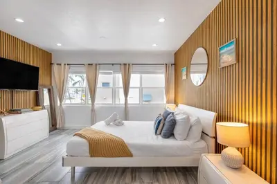 a bedroom with a large bed and a television at Ocean Views! Steps from Dining, Shopping, Las Olas in Fort Lauderdale