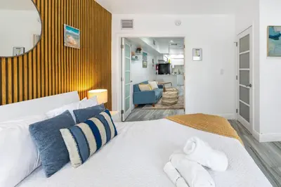 a bedroom with a large bed with blue and white pillows at Ocean Views! Steps from Dining, Shopping, Las Olas in Fort Lauderdale