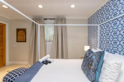 a bedroom with a white bed with a blue headboard at Miami House - Heated Pool - Family Vacation in Miami