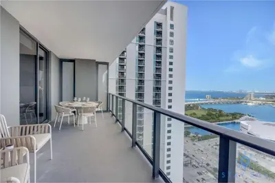 a balcony of a building with a table and chairs at Apartment 3BR-3 BTH - Gym & Pool in Miami