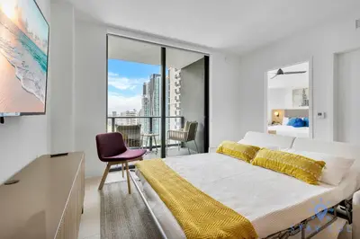 a bedroom with a large bed and a balcony at Modern 1BR Apartment with Pool in Miami