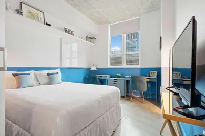 a bedroom with a bed and a desk and a television at City Loft - Downtown Bayfront pool gym & parking in Miami