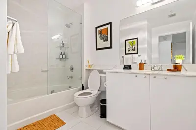 a white bathroom with a tub and a toilet and a sink at City Loft - Downtown Bayfront pool gym & parking in Miami