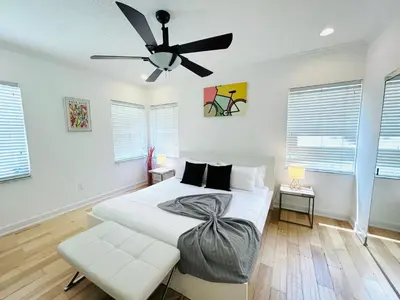 a bedroom with a bed and a ceiling fan at Heated Pool Tropical House with Summer Kitchen 3BR- Oasis in Miami! in Miami
