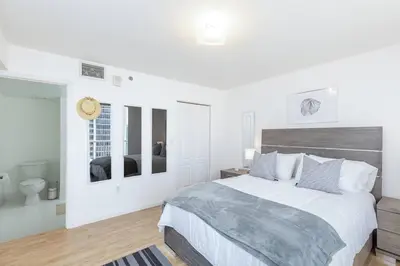 a white bedroom with a large bed and a bathroom at Spacious 29th Floor 1 BED 1 BTH Brickell Ocean View in Miami