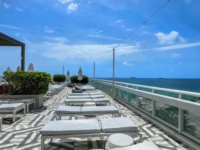 a row of chaise lounges and chairs on avisorvisor at 2BR W Residence FLL, OCEAN VIEWS, Infinity pool, hot tub, large balcony, easy amentiy access in Fort Lauderdale