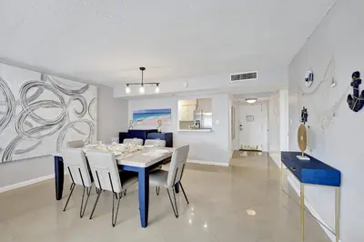 a dining room with a blue table and white chairs at Breathtaking 2 Bedroom Condo w Beach Service 919 in Miami Beach