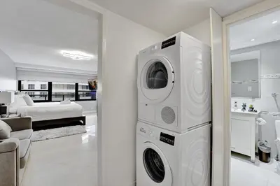 a washer and dryer in a room with a bedroom at Breathtaking 2 Bedroom Condo w Beach Service 919 in Miami Beach